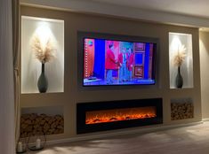 a flat screen tv mounted to the side of a wall next to a fire place