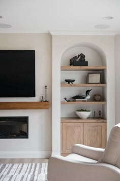 a living room filled with furniture and a flat screen tv mounted on the wall above a fireplace