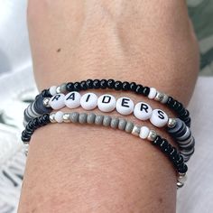 🏈 Who loves football? Who loves the Las Vegas Raiders? Show your team spirit with this fun bracelet set! Great for gift giving!! Lightweight and oh so comfy to wear. You will receive 3 bracelets that are made on strong stretch cord and made to fit a 7 1/2" wrist. Need a different size? Just let me know your wrist size and I will be happy to custom make for you! Each piece is handmade with: - High Quality Glass Seed Beads - Silver High Quality Seed Beads that won't tarnish* - Heishi Vinyl Beads - White/Black Acrylic Letter Beads - Stretch Cord: high-quality cord with reinforced knots Easily layer with other Luna by Rachel bracelets for a stunning stack! My pieces are made sturdy, but as with all jewelry, they are also delicate and should be treated with care. Be sure to check out other des Seed Bead Stacking Bracelets, Sports Team Beaded Bracelets, Game Day Team Spirit Stretch Bracelet With Round Beads, White Beaded Bracelets For Football Season, Black Adjustable Beaded Bracelets Team Spirit Style, Black Team Spirit Adjustable Beaded Bracelets, Personalized Adjustable Beaded Bracelets For Football Season, Black Adjustable Beaded Bracelets For Team Spirit, Team Spirit Bracelets With Letter Beads