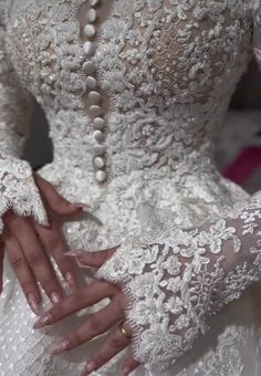 a woman in a white wedding dress with pearls on her hands and the back of her hand