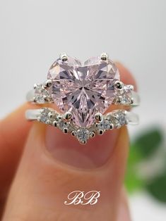 a heart shaped pink diamond ring with white diamonds