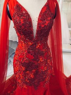 a red dress on display in front of a mannequin