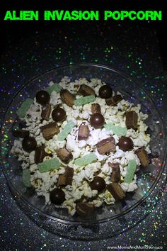 a glass bowl filled with popcorn and candies