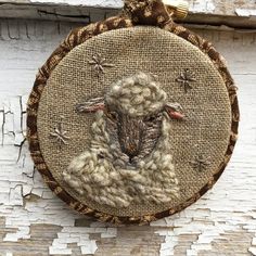 a close up of a sheep on a piece of cloth hanging from a wall with wood