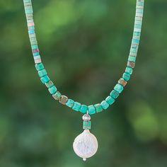 Mystic as the sea, this beaded necklace combines ethereal colors for a stylish look. Thailand's Somluck Komolmith uses reconstituted turquoise jewels to create this bohemian necklace, accented with a cultured pearl pendant in a natural white tone—like a moon over the ocean. The accessory has a sterling silver clasp and extender. Bohemian Turquoise Pearl Necklace With Colorful Beads, Bohemian Beaded Turquoise Pearl Necklace, Adjustable Bohemian Turquoise Pearl Necklace, Bohemian Turquoise Beaded Pearl Necklace, Bohemian Turquoise Pearl Necklace With Gemstone Beads, Bohemian Pearl Necklace With Polished Beads, Moon Over The Ocean, Ethereal Colors, Quartz Choker