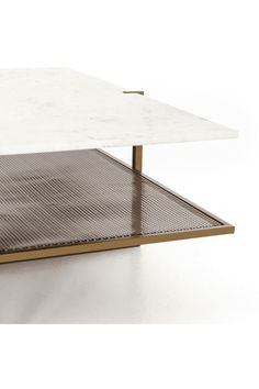 a white marble and brass coffee table with mesh under the top, on a white background