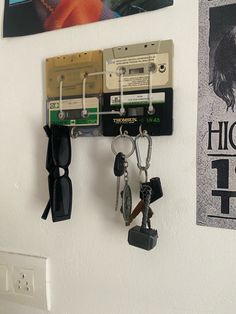 there are several keys hanging on the wall next to some tape recorders and sunglasses