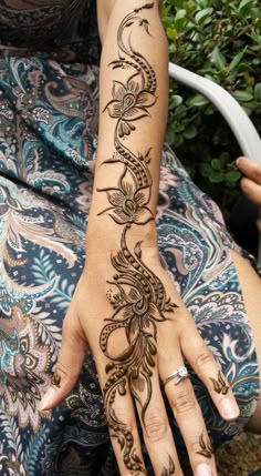 a woman's hand with hennap on it, and the arm is decorated with