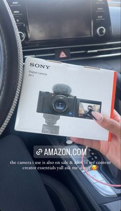 a person holding up a camera in their car's dashboard with the text sony on it