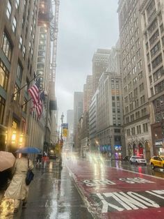 people with umbrellas are walking down the street on a rainy day in new york city