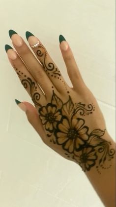 a woman's hand with henna tattoos on it