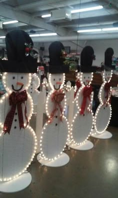 several snowmen are decorated with lights and bows