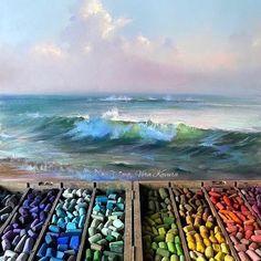 there are many different colored crayons in the box next to each other on the beach