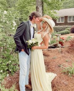 a bride and groom kissing in front of a tree