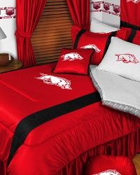 a bed with red and white comforters in a bedroom