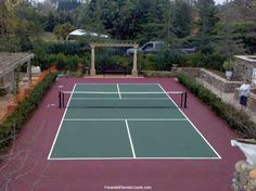 a tennis court surrounded by trees and bushes