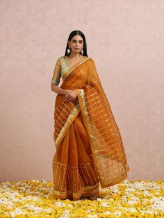 Featuring a rust silk organza saree with gota placements all over. It is paired with a rust blouse having gota and hand embroidery. Color: Rust Fabric: Sari - Organza Silk Blouse - Chanderi Note: Available in other colors The product will be shipped within 30-35 days of order placed Wash care - Dry Clean Only. Do not use heavy Iron Rust Saree, Traditional Orange Saree With Gota Work, Transitional Raw Silk Pre-draped Saree With Gota Work, Luxury Orange Saree With Gota Work, Semi-stitched Orange Saree With Gota Work, Orange Silk Unstitched Blouse Piece, Rust Blouse, Organza Silk Saree, Organza Saree