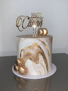 a white and gold birthday cake on a table