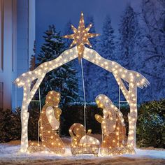 a lighted nativity scene in the snow