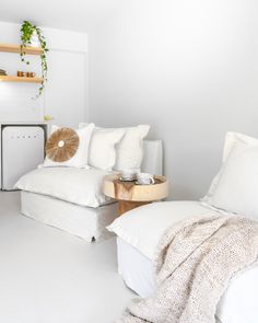 a white room with two beds and pillows