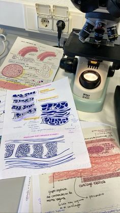 a microscope sitting on top of a table next to papers