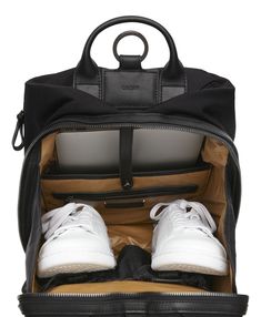 an open black backpack with white shoes inside