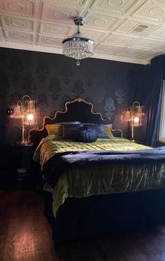 a bed sitting in a bedroom under a chandelier next to two lamps on either side of the bed