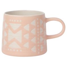 a pink and white mug with geometric designs on it