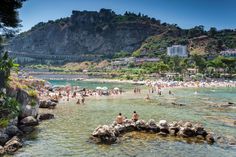 many people are on the beach and in the water