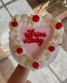 a heart shaped cake with cherries in the shape of a baby's name