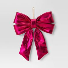 a pink bow hanging on a white wall