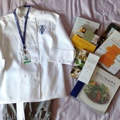 a white jacket and some books on top of a bed next to a blue lanyard