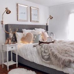 a bedroom with white walls and lights on the headboard is decorated in neutral tones