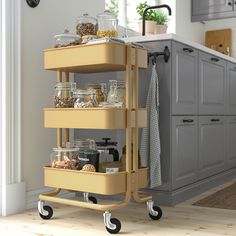 a kitchen cart filled with lots of food on top of a hard wood floor