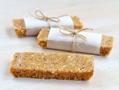 three pieces of food sitting next to each other on a white tablecloth with twine