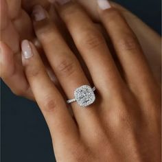 a woman's hand holding an engagement ring with a diamond in the middle and on it