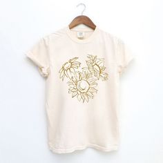 Looking for a cute versatile top to wear? Make sure to grab one of our Graphic tees! This soft and comfortable graphic tee is the perfect top for any outfit. It can be paired with biker shorts, jeans, or even a simple skirt/dress! This tee is true-to-size, so be sure to order your regular t-shirt size! If you are looking for a more oversized look, make sure to size up! Summer Beige T-shirt With Screen Print, Beige Screen Print T-shirt For Summer, Spring Cream Top With Screen Print, Cream Tops With Screen Print For Spring, Cream Screen Print T-shirt For Summer, Spring Bleached Relaxed Fit T-shirt, Spring Soft-washed Cream Top, Soft-washed Cream Top For Spring, Relaxed Fit Bleached T-shirt For Spring