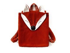 a red backpack with a white fox head on the front and back flaps down