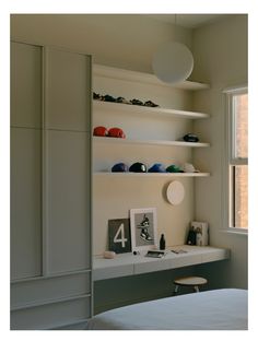 a bedroom with white walls and shelves on the wall