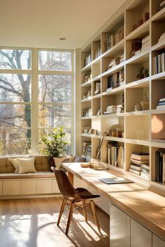 a home office with lots of bookshelves and a desk in front of a window