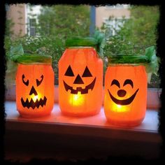 three mason jars decorated with pumpkin faces are sitting on a window sill