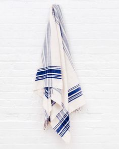 a white and blue towel hanging on a brick wall