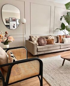 a living room filled with furniture and a mirror on the wall above it's headboard