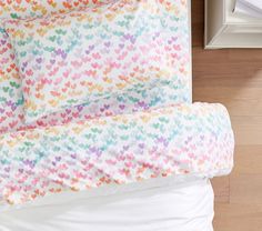 a bed with colorful hearts on it and white sheets