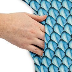 a woman's hand on the back of a blue fish scale wallpaper pattern