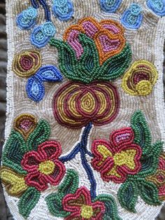 an embroidered piece with flowers and leaves on the side of a tablecloth that has been stitched together