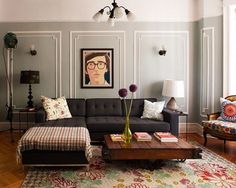 a living room filled with furniture and a painting on the wall above it's coffee table