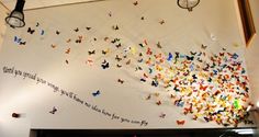 there is a wall with many butterflies on it and a light hanging from the ceiling