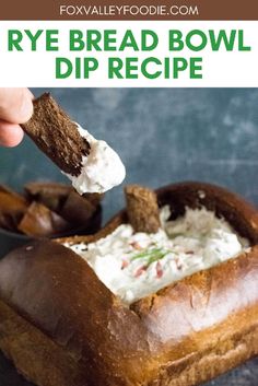 a person dipping dip into a bread bowl