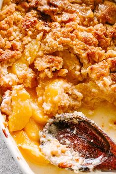 a casserole dish with meat and fruit on the side, ready to be eaten